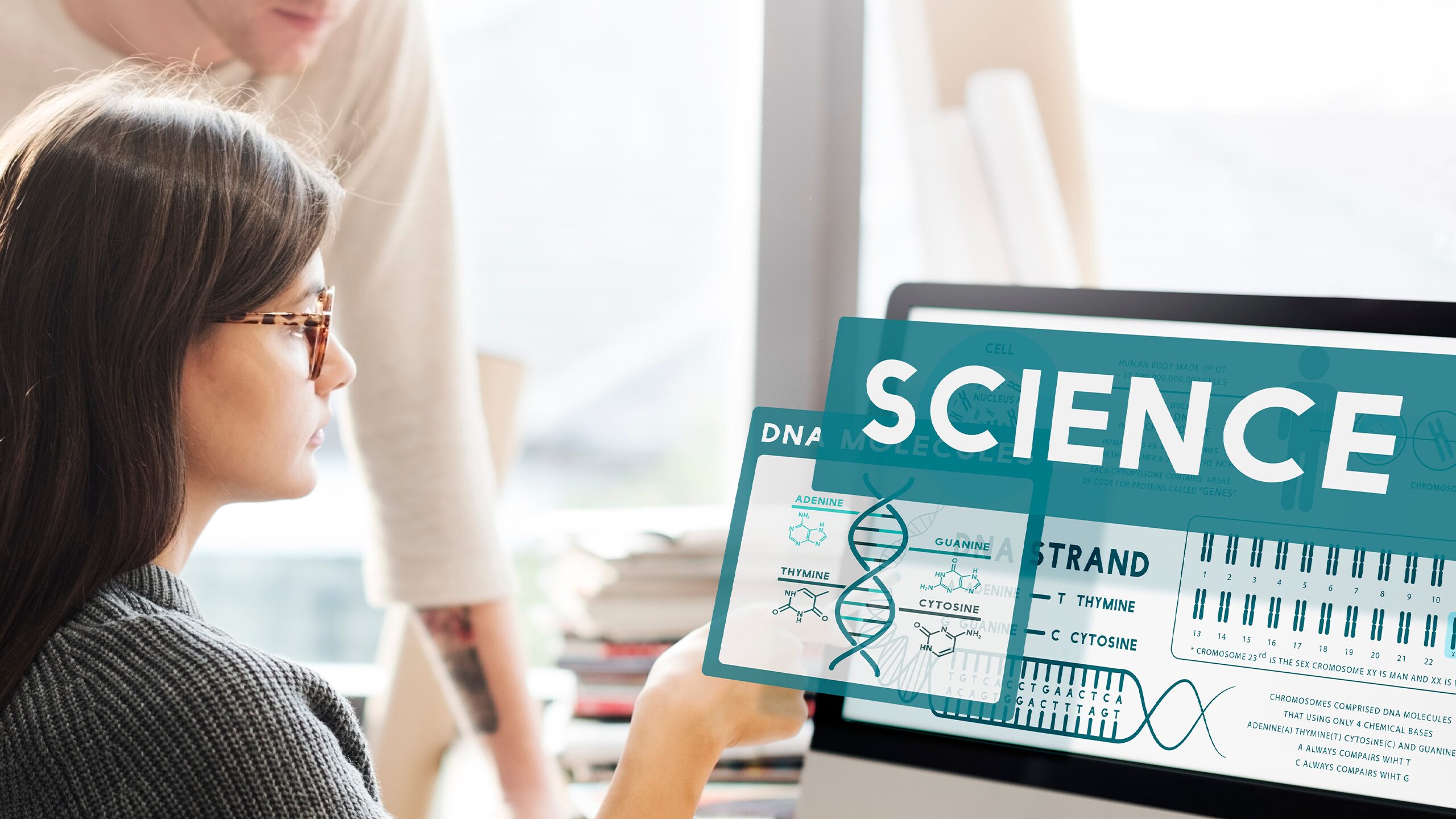 A woman and man focused on a computer screen displaying the word "science," symbolizing Engineering and Natural Science Management.