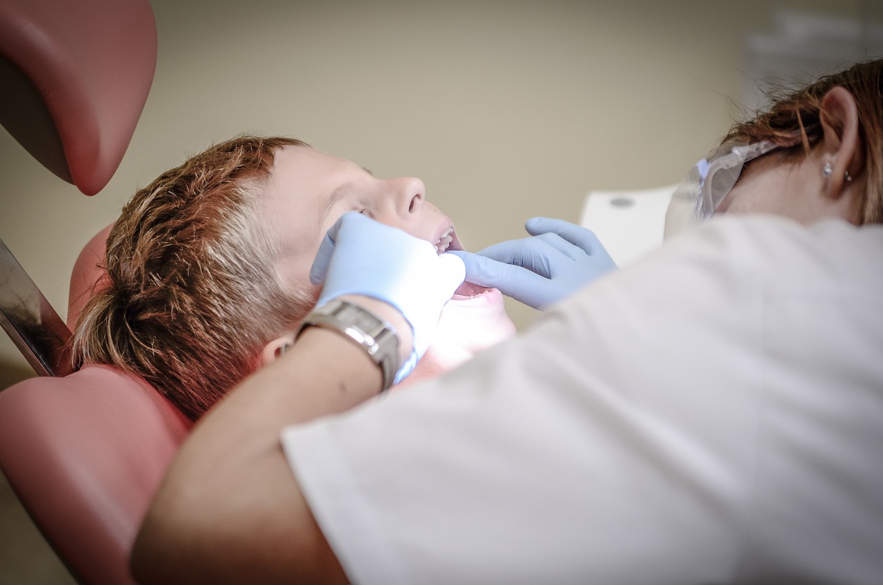 A dentist checking a child's teeth, emphasizing the role of dental hygiene services in maintaining oral health.