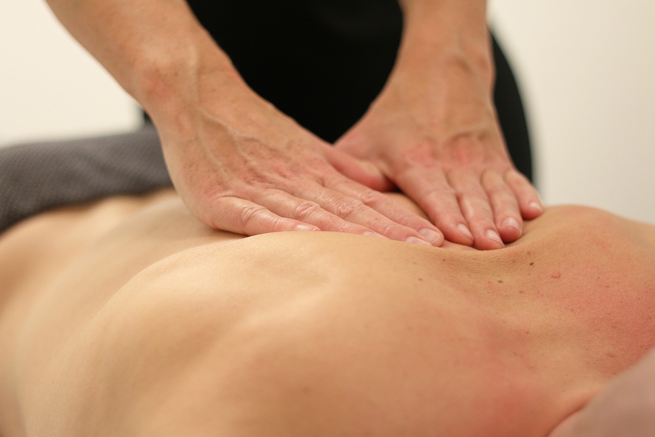 person receiving a soothing back massage in a tranquil therapy room, showcasing a professional massage therapy practice.