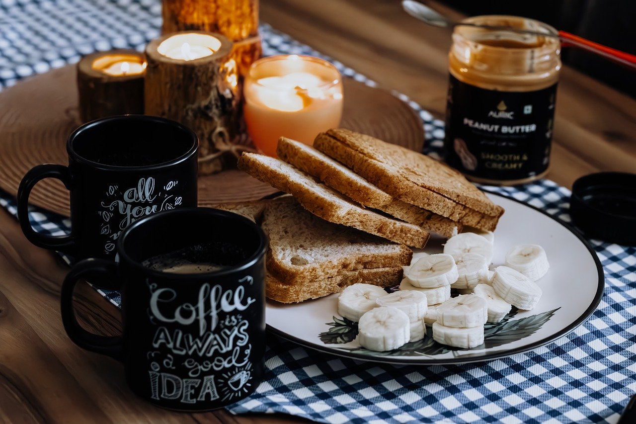 A cozy breakfast scene featuring coffee, toast, and bananas arranged on a table, ideal for a food service establishment's menu.