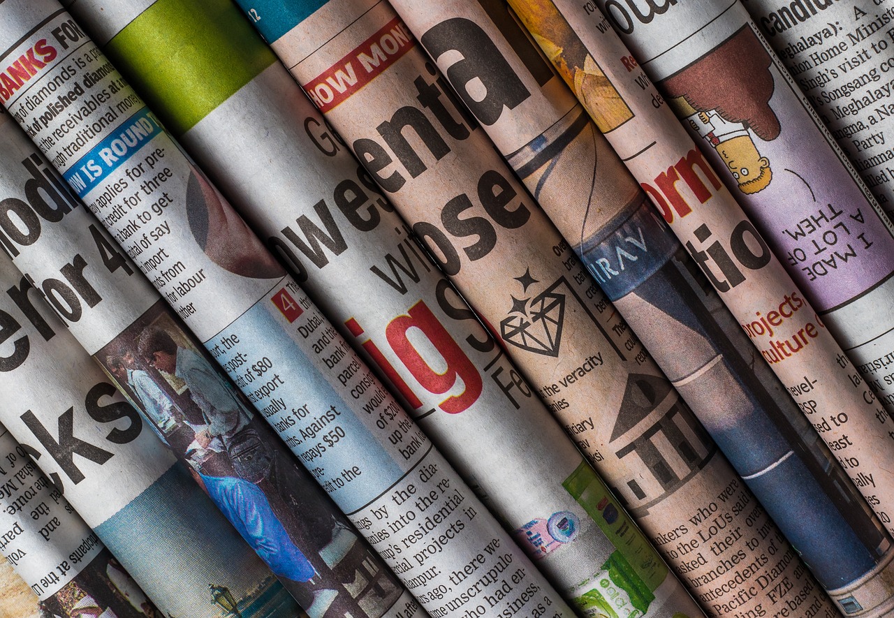 A diverse stack of newspapers showcasing various news articles, representing a media and news agency's extensive coverage.