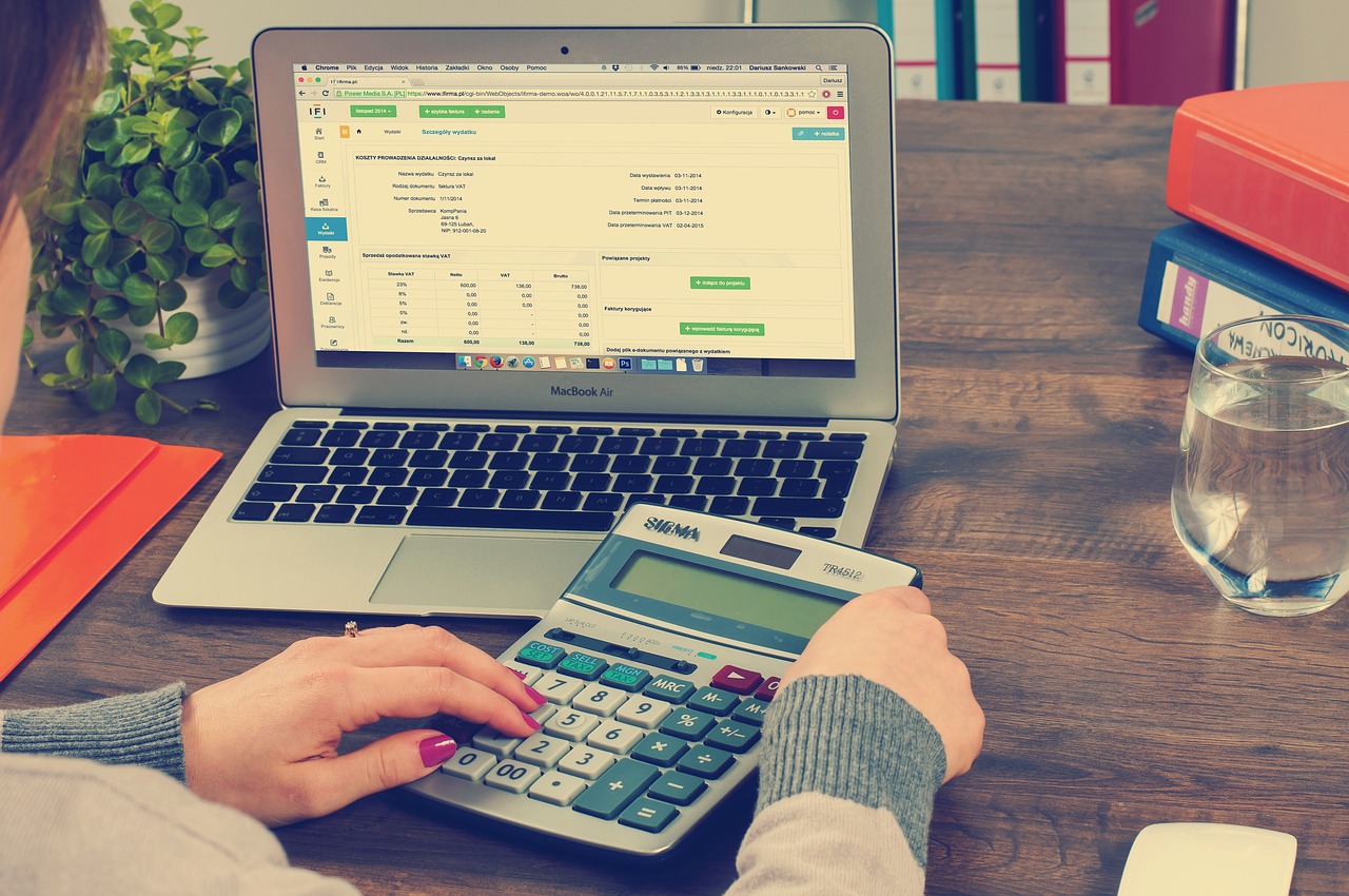 A business owner calculates expenses on a laptop, demonstrating her expertise in billing and posting services.