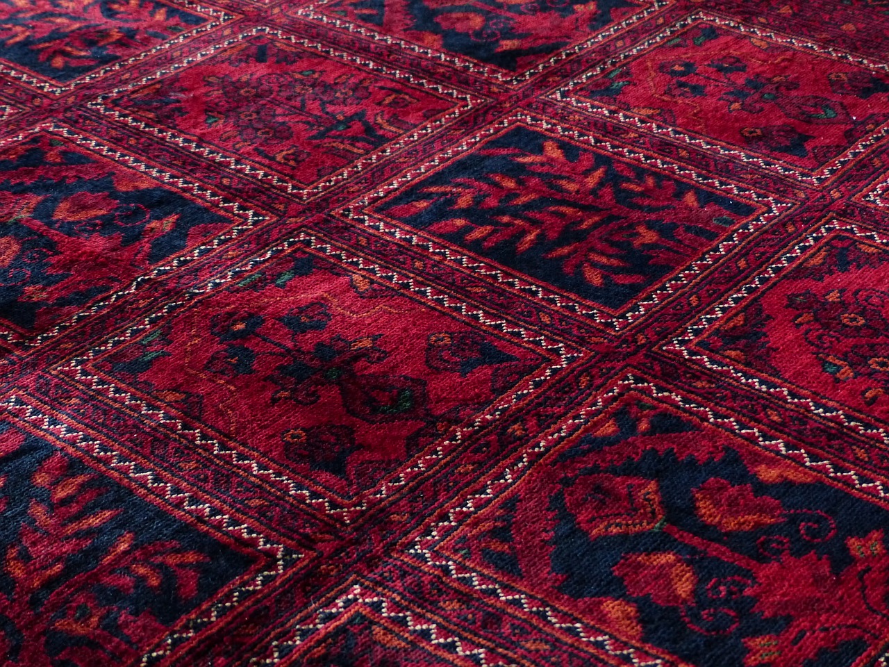 A close-up view of a red and black rug, showcasing its intricate patterns and textures, ideal for flooring solutions.