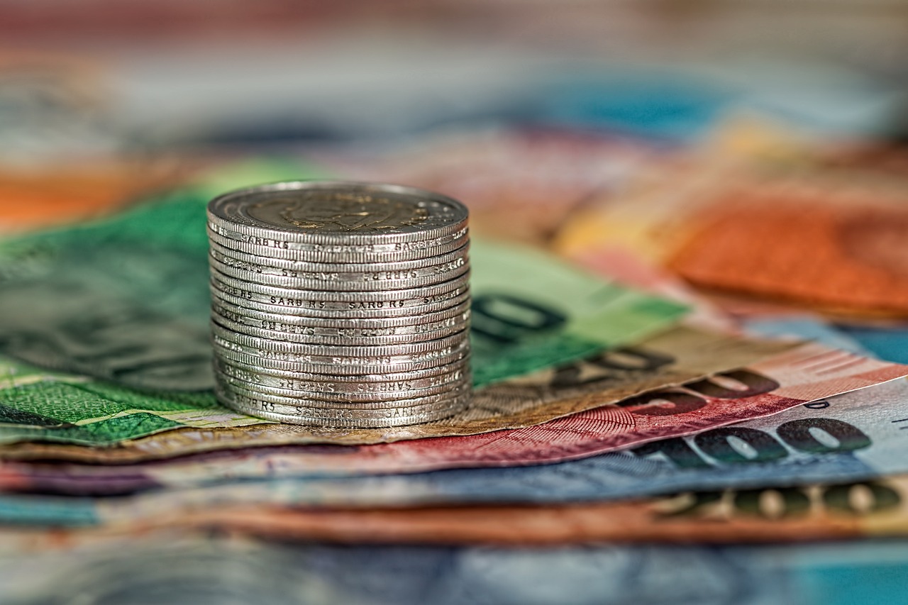 A stack of bills alongside a stack of coins, symbolizing financial transactions and banking services.