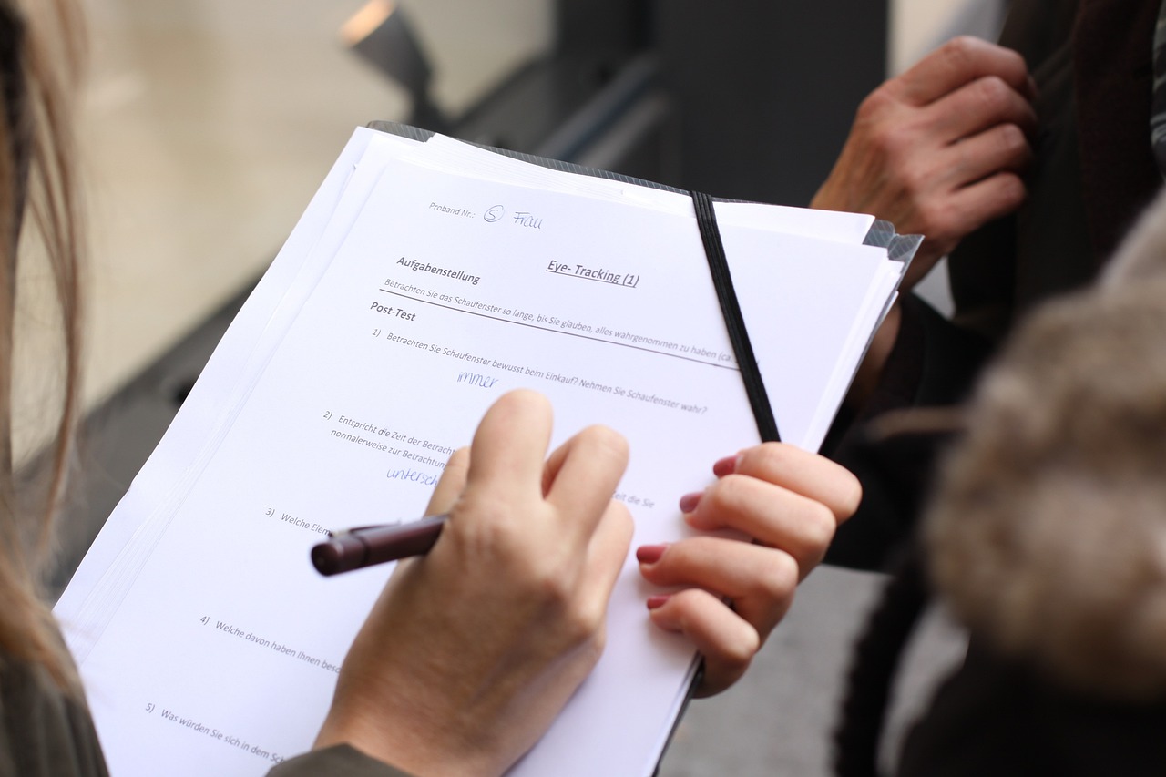 A business owner in surveying and mapping services holds a paper and pen, preparing to take notes or draft plans.