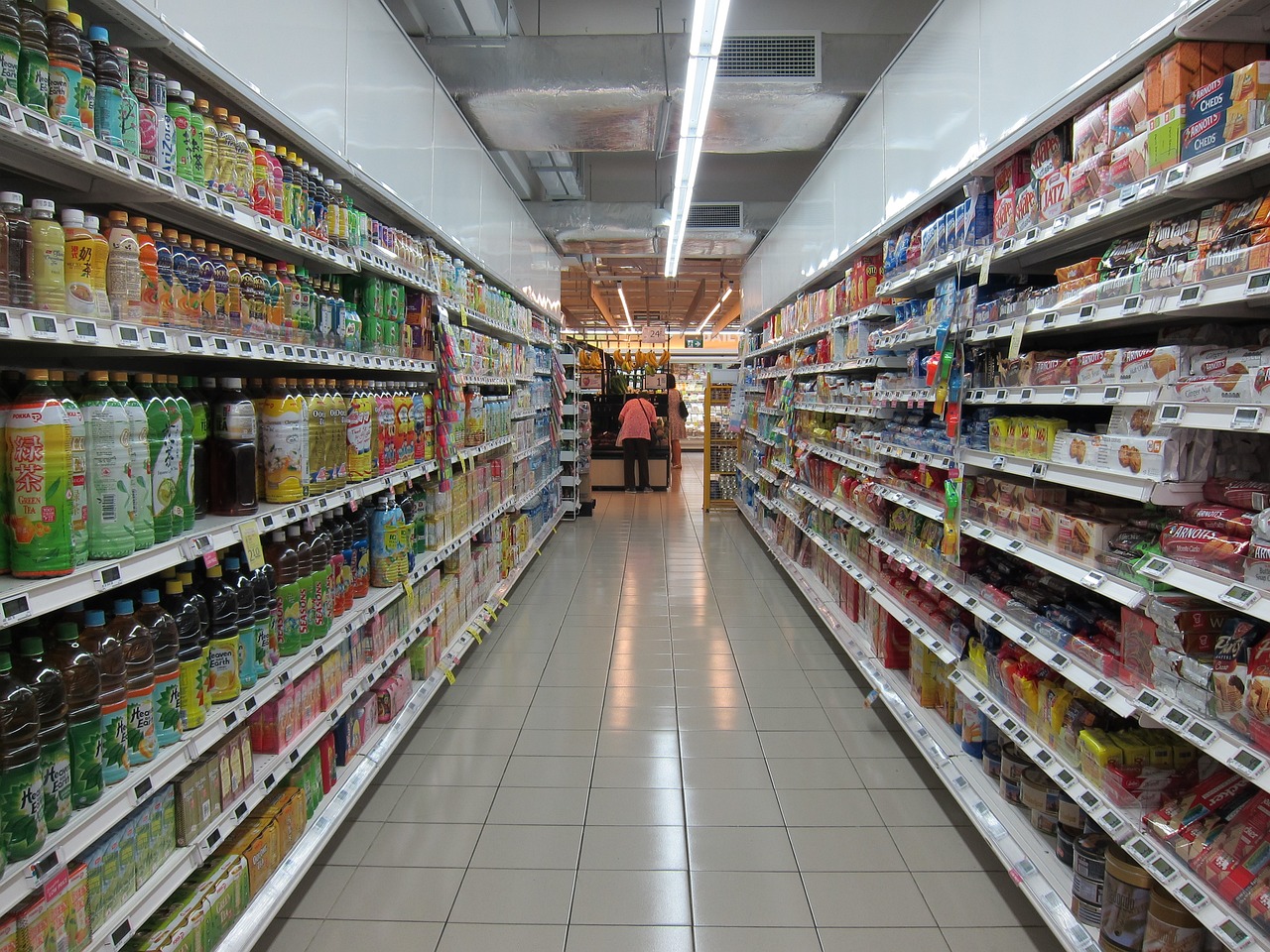 A long aisle in a supermarket showcasing various products, emphasizing the retail environment for business owners.