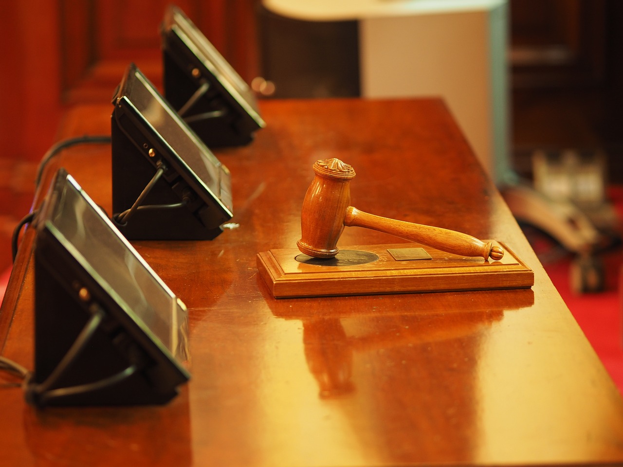 Image featuring wooden desk with a wooden gavel placed on it, illustrating the professional environment of court reporting services.