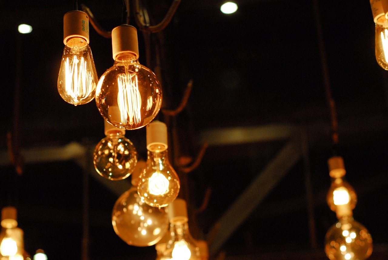 A variety of light bulbs hanging from the ceiling, showcasing the creativity and expertise of an electrical services company.