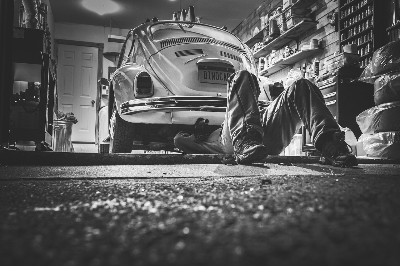 A man performing maintenance on a car in a garage, showcasing diesel repair and maintenance services.