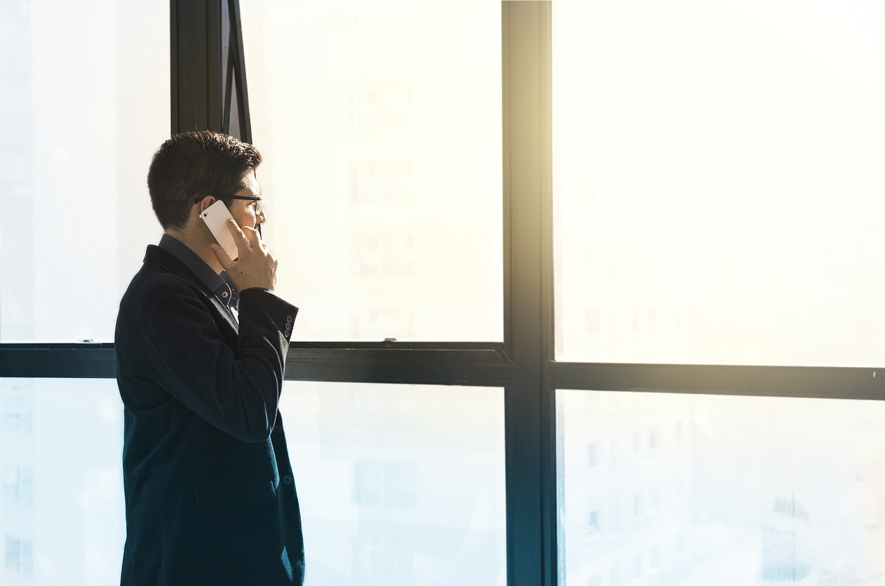 An Operations Research Consultancy owner in a suit talks on a cell phone, illustrating professionalism and business engagement.