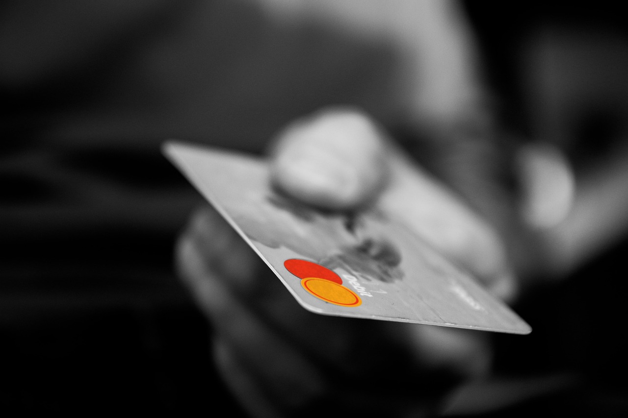 Image featuring Individual grasping a credit card, representing the essential duties of credit checkers and clerks in financial services.