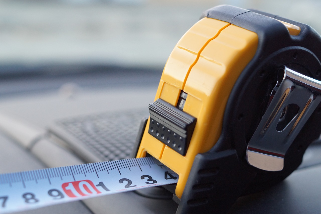 A yellow tape measure highlighting the practical tools used by a carpentry business owner.