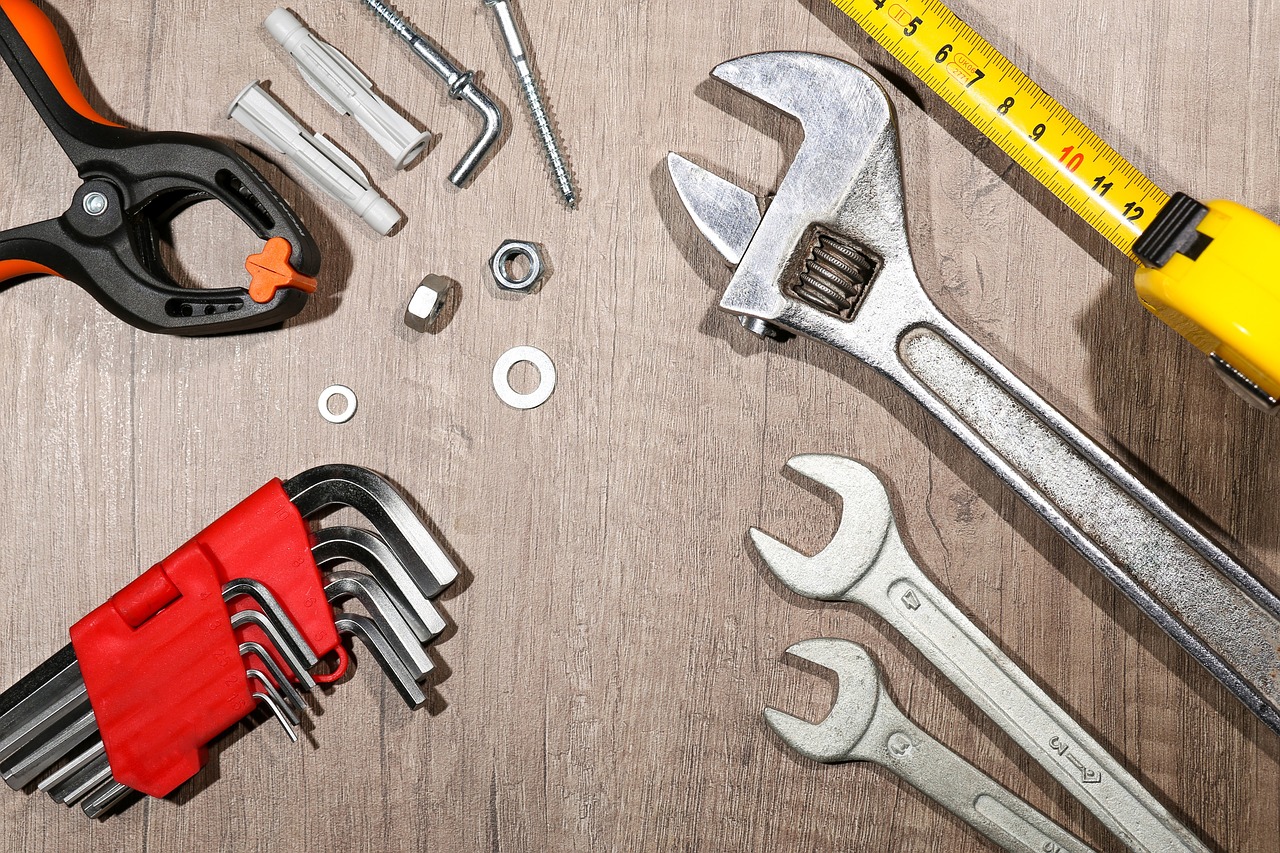 A collection of various tools arranged on a wooden surface, symbolizing maintenance and repair services.